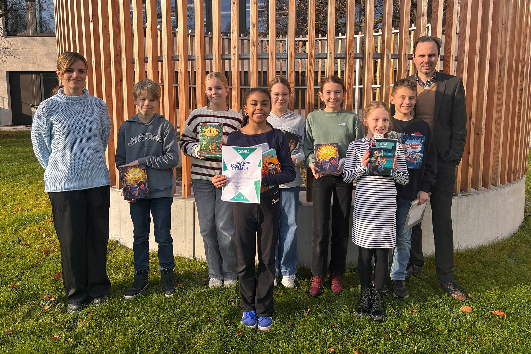 Gruppenfoto der Teilnehmer am Vorlesewettbewerb sowie die Siegerin