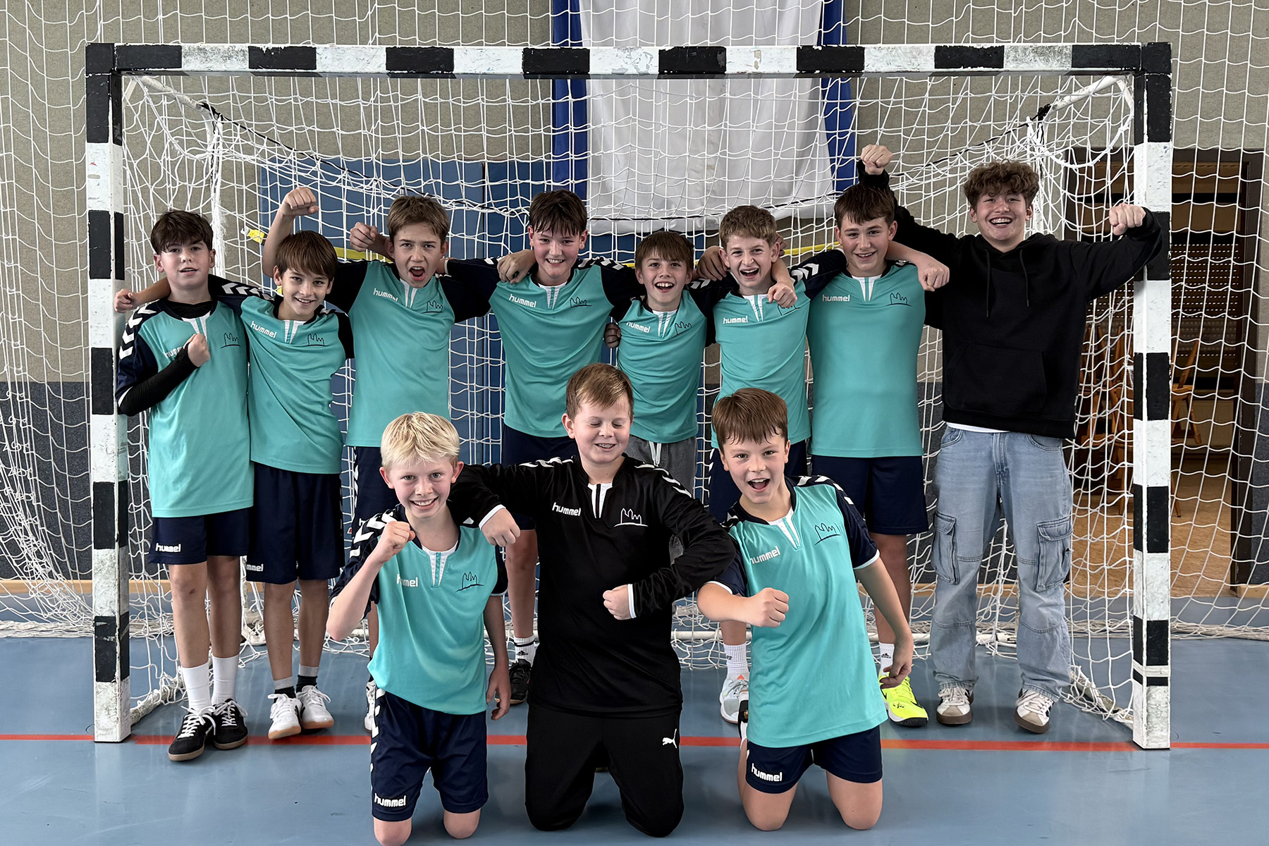 Gruppenfoto der Jungen-IV-Handballmannschaft vor dem Tor