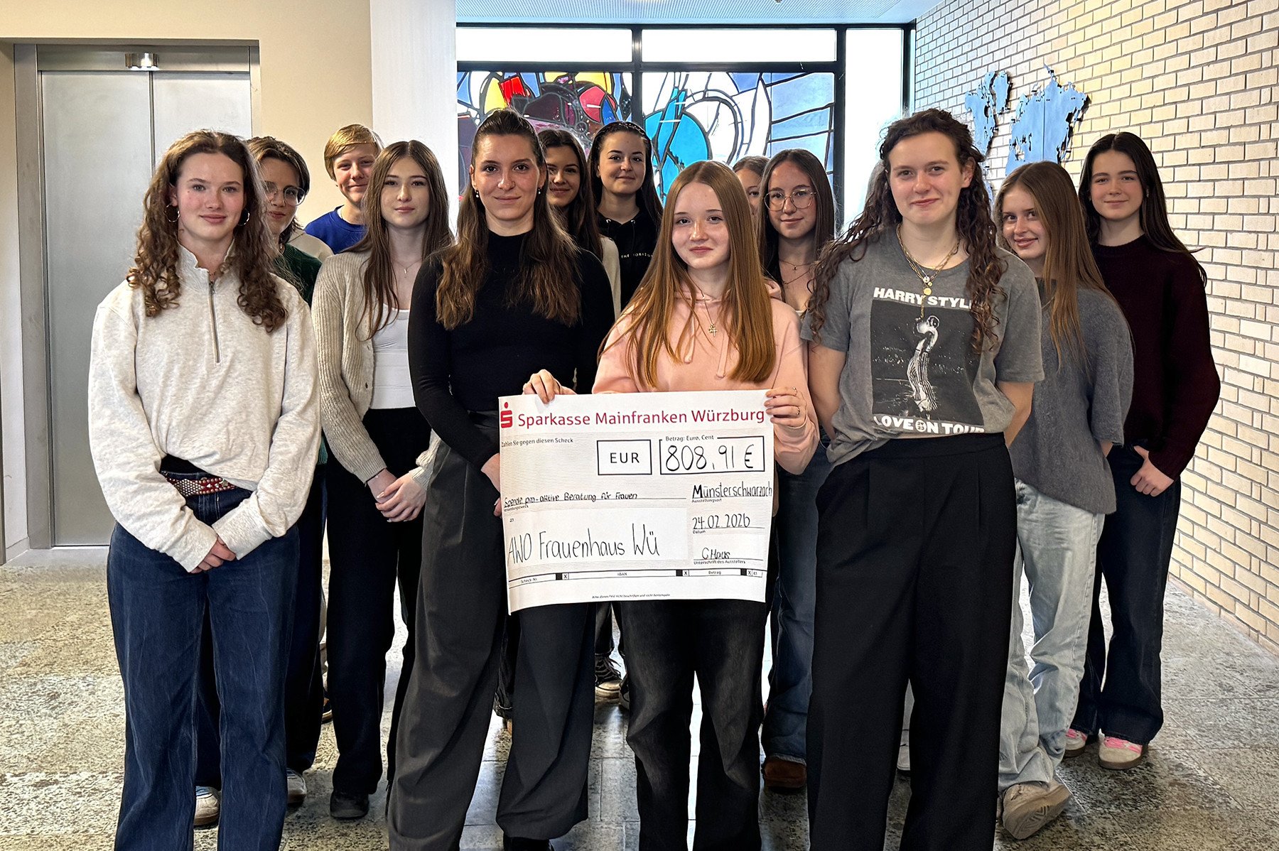 Gruppe von Schülerinnen mit einem großen Scheck