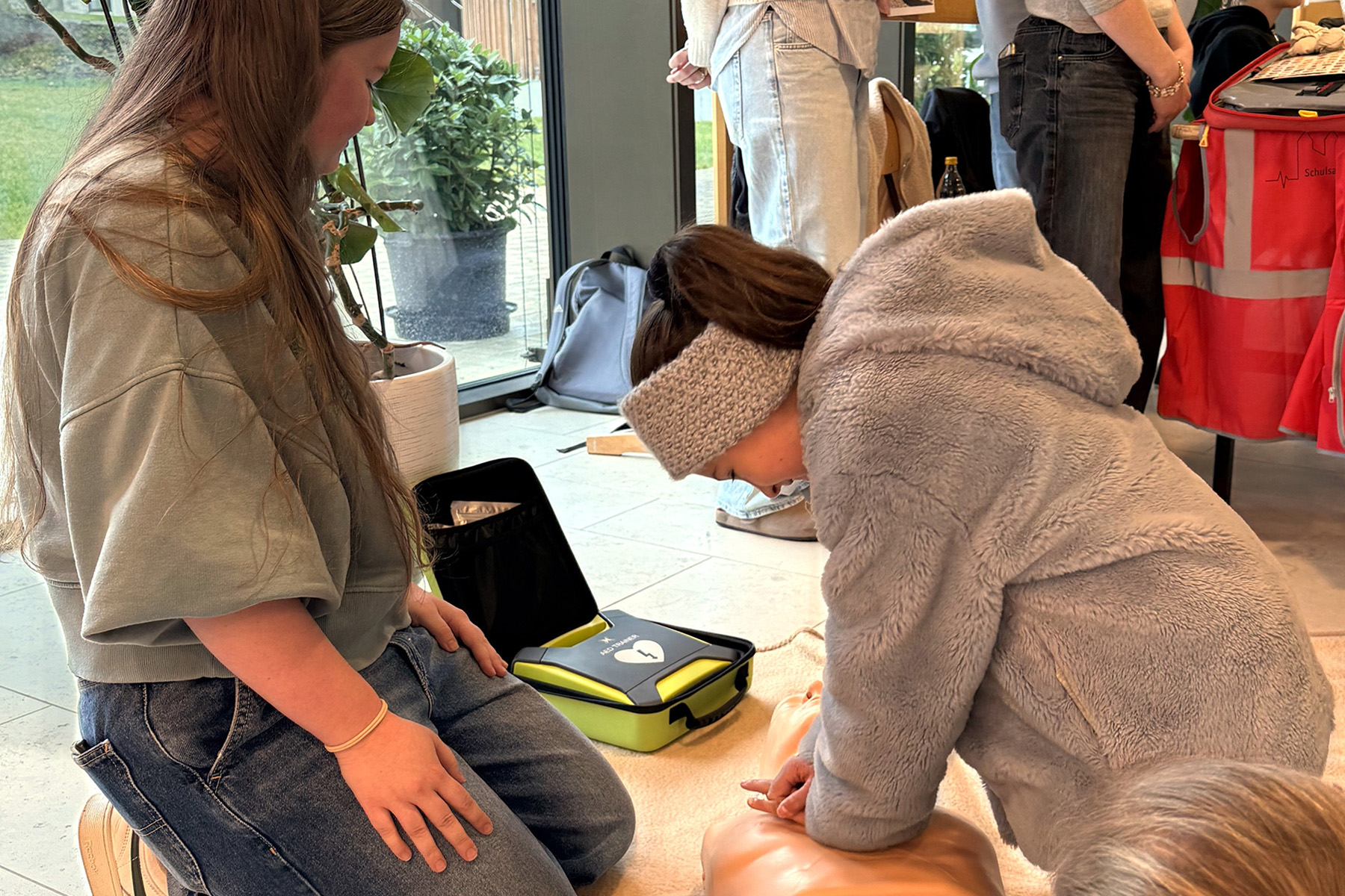 Schülerin übt erste Hilfe am Kissen