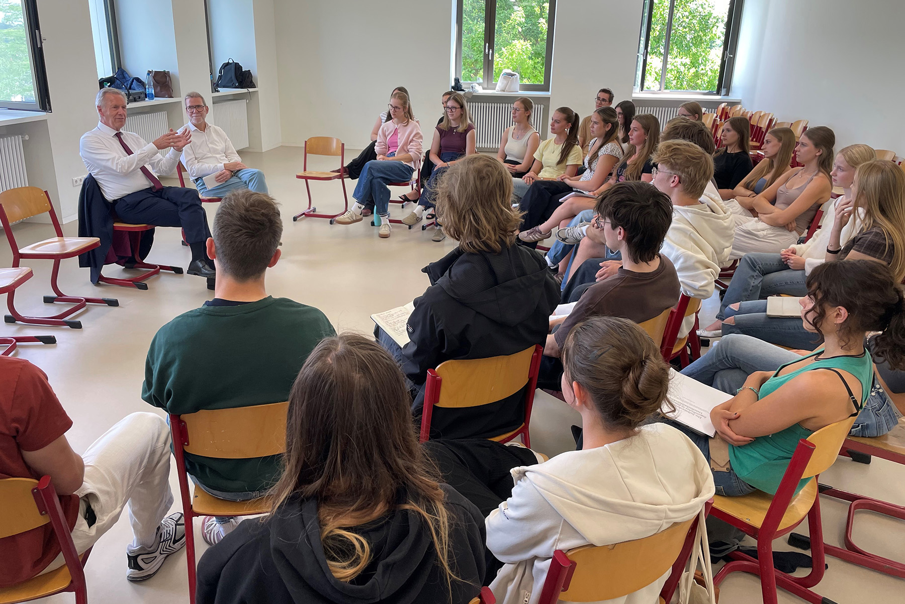Ex-Bundespräsident Wulff sitzt in einem Klassenzimmer, Schülerinnen und Schüler vor ihm in einem Stuhlhalbkreis