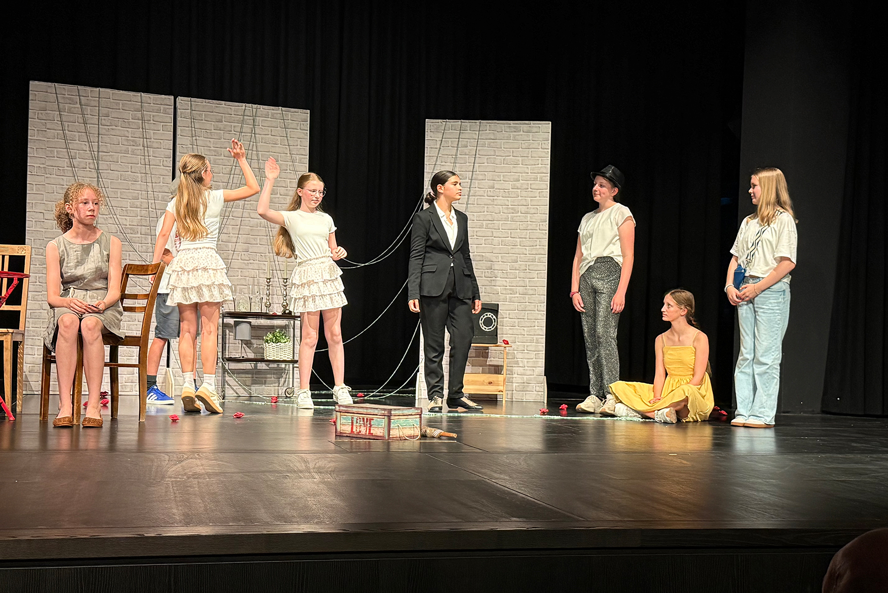 Sieben Schülerinnen der Theatergruppe bei der Aufführung auf der Bühne