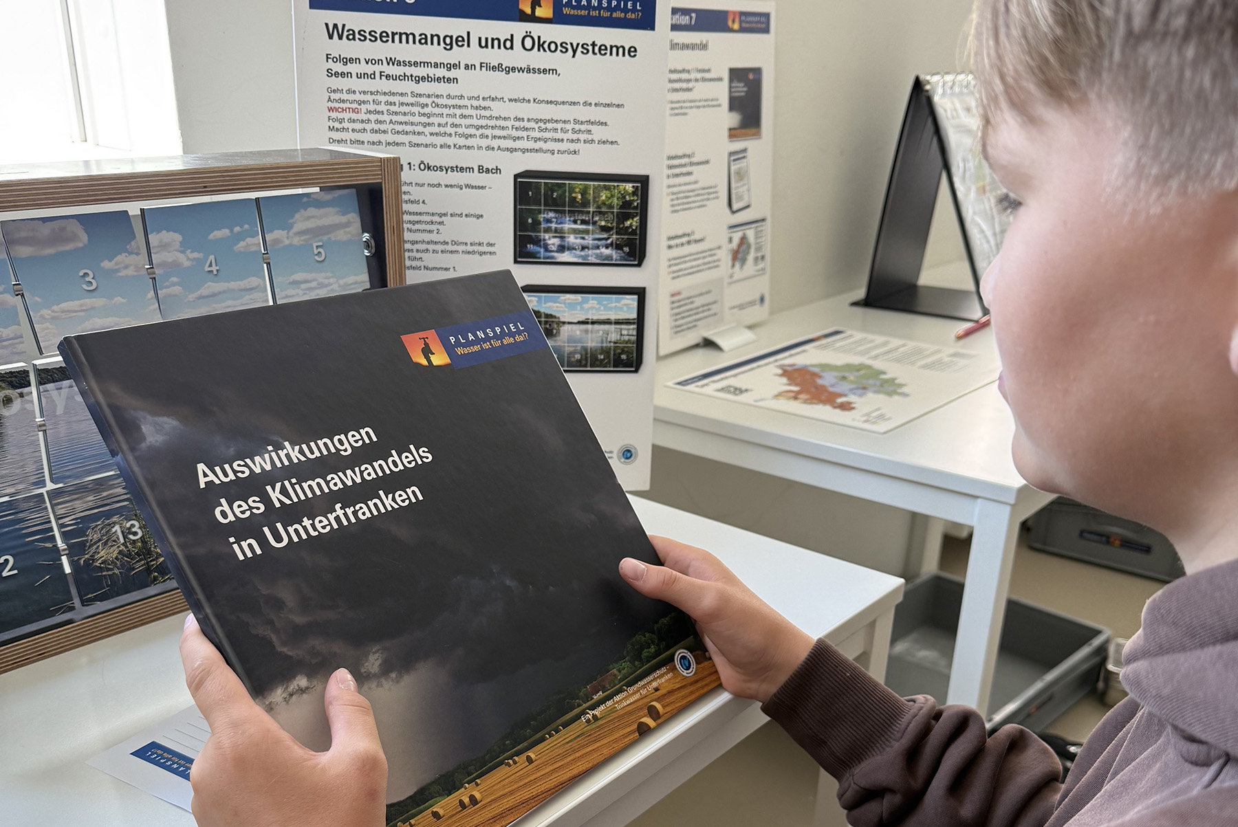 Ein Schüler schaut sich Unterlagen vom Planspiel an.