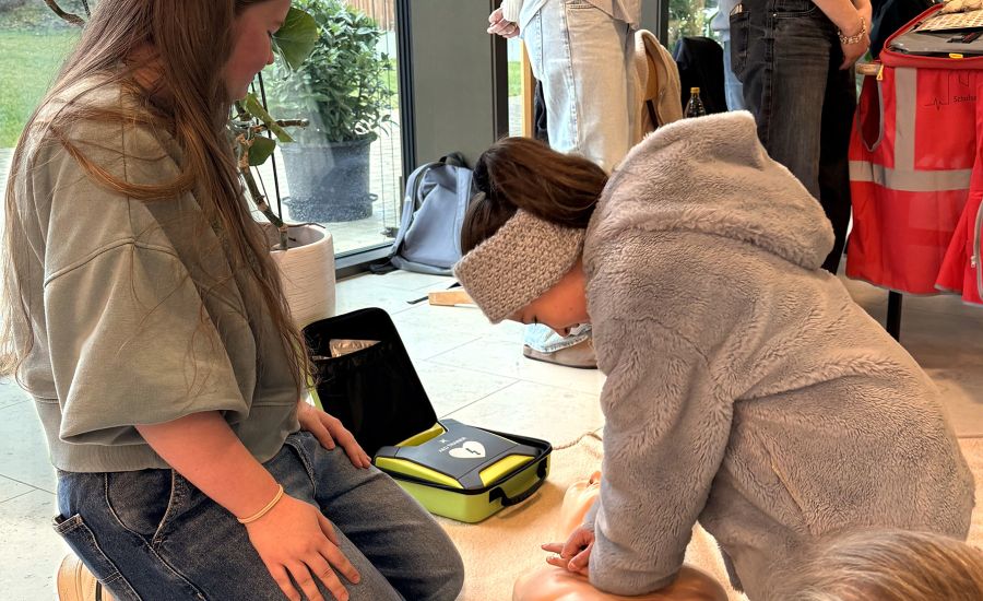 Schülerin übt erste Hilfe am Kissen