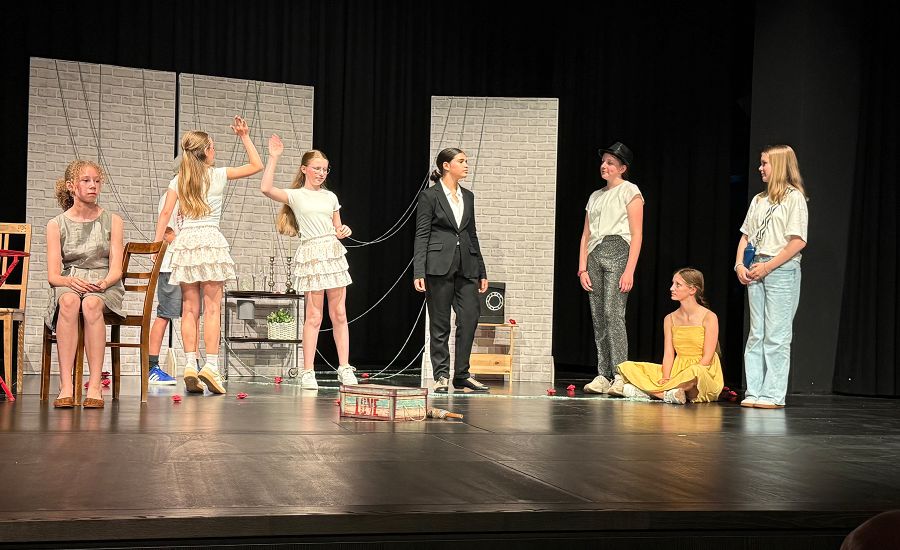 Sieben Schülerinnen der Theatergruppe bei der Aufführung auf der Bühne