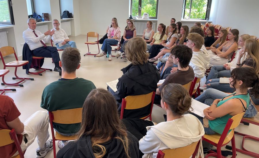 Ex-Bundespräsident Wulff sitzt in einem Klassenzimmer, Schülerinnen und Schüler vor ihm in einem Stuhlhalbkreis